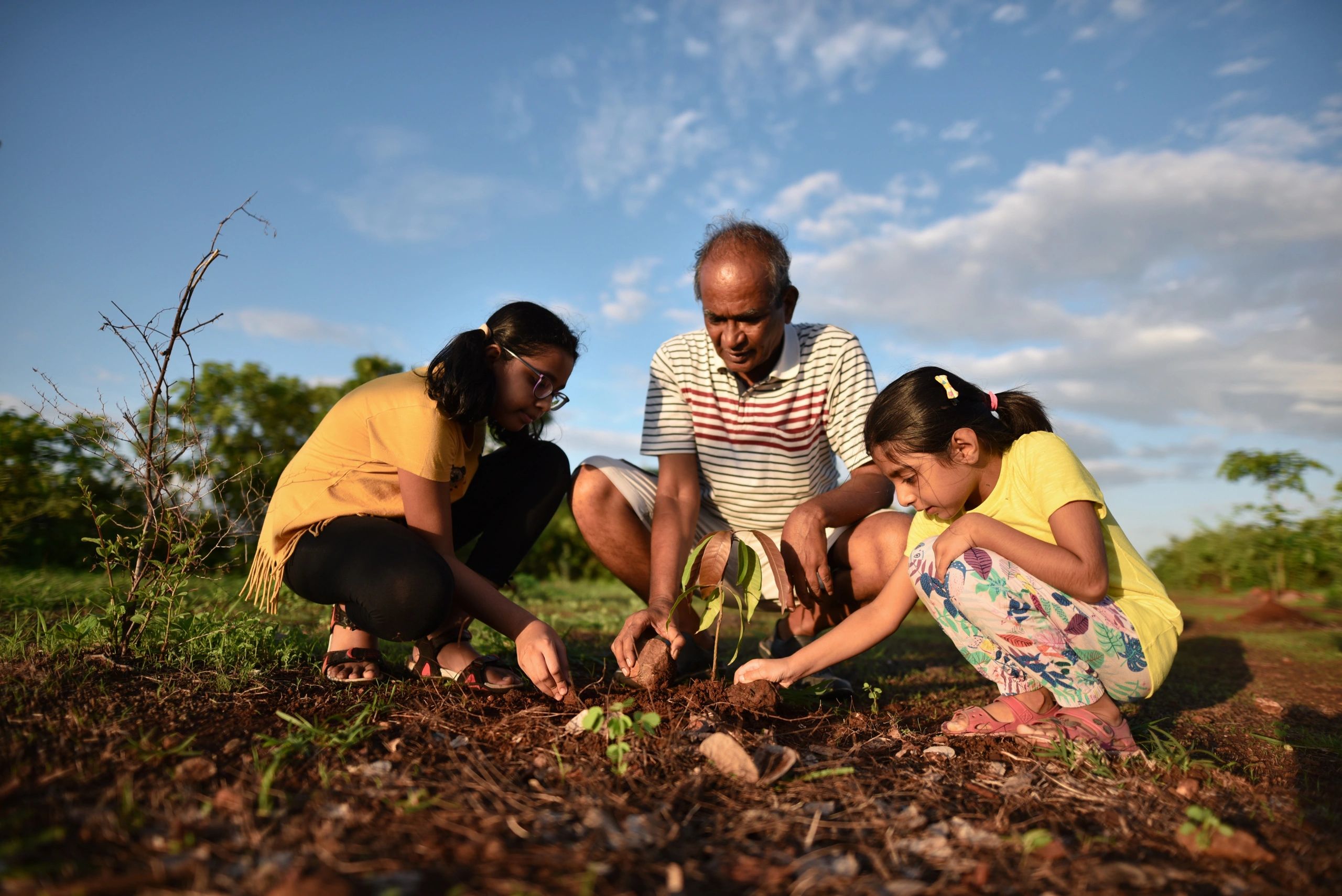 Family planting a tree representing rural community coverage